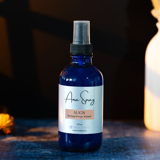 Blue aura spray bottle with a label on a dark background